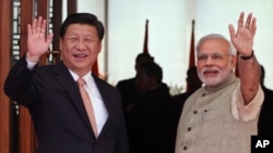 17일 인도를 방문한 시진핑 중국 국가 주석(왼쪽)이 나렌드라 모디 인도 총리와 함께 취재진을 향해 손을 흔들고 있다.