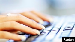 FILE - A woman uses a computer keyboard.