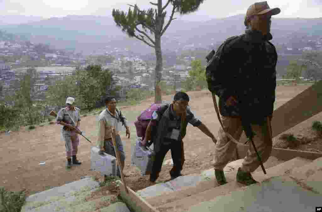 Polling officials carry electronic voting machines to a voting center on the eve of the second phase of Indian parliamentary elections at Senapati, in north eastern Manipur state, India, Tuesday, April 8, 2014. India started the world's largest election M