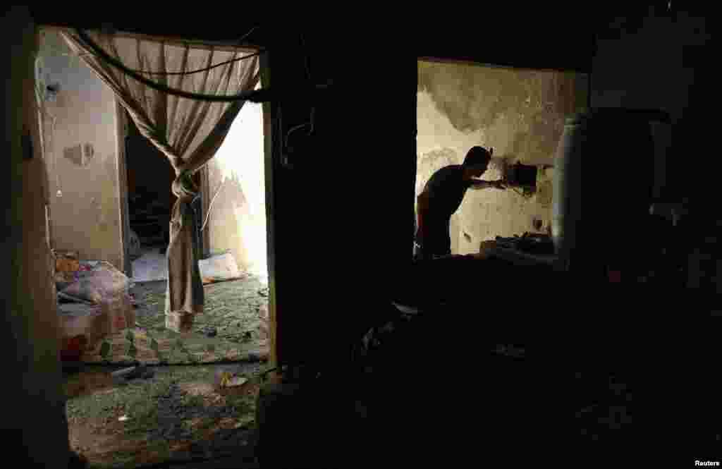 A Palestinian man inspects a house which police said was damaged in Israeli shelling that killed two boys and a man from&nbsp; the Nutaiz family, in Gaza City, July 18, 2014.