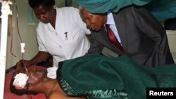 Tanzania's Vice President Mohamed Gharib Bilal consoles a faithful at Mount Meru Hospital, who was injured during an explosion at the new Catholic church, in the northern Tanzanian town of Arusha, May 6, 2013.