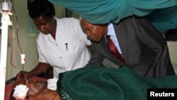 Le vice-président tanzanien Mohamed Gharib Bilal console une victime de l'explosio à l'hôpital Mount Meru (6 mai 2013)