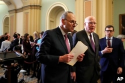 Senate Minority Leader Sen. Chuck Schumer of New York, center, walks with Sen. Patrick Leahy, D-Vt., right, as they leave a news conference with Democratic leaders, March 20, 2018, on Capitol Hill in Washington.