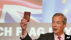 FILE - UKIP Leader Nigel Farage holds up a British passport, with the EU burgundy sleeve, as he makes a speech in London, June 22, 2016, before the Brexit vote.