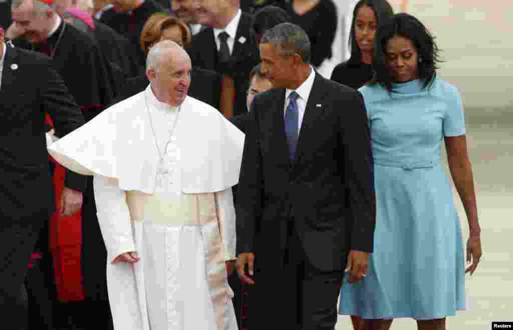 Pope Francis, left, is greeted by U.S. President Barack Obama and first lady Michelle Obama upon his arrival at Joint Base Andrews outside Washington, Sept. 22, 2015.