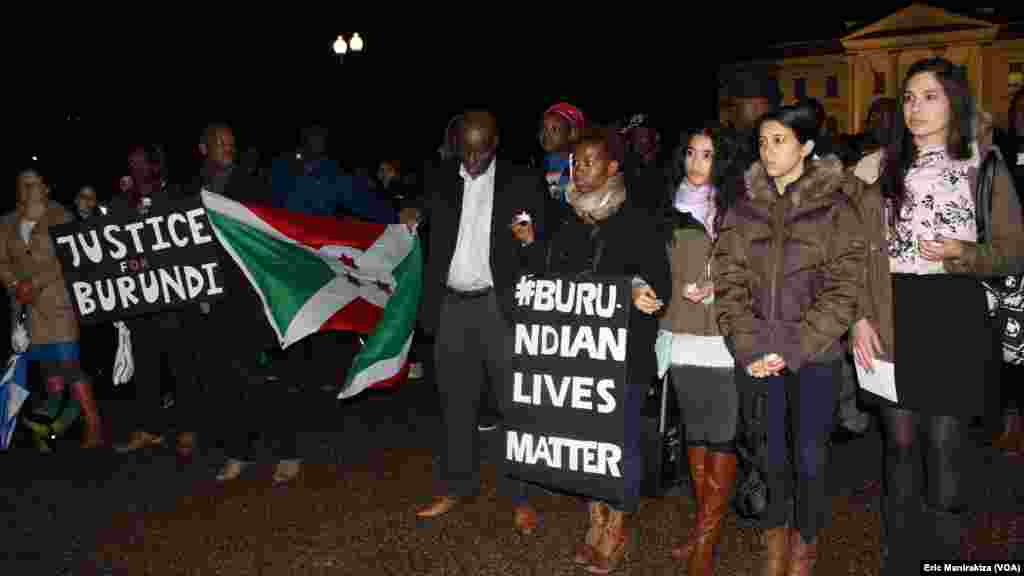 Quelques personnes tiennent des calicots avec mention "justice au Burundi" et "la vie des Burundais d'abord" durant le recueillement devant la Maison Blanche, en mémoire des victimes de la tuerie du weekend dernier dans certains quartiers de Bujumbura, au