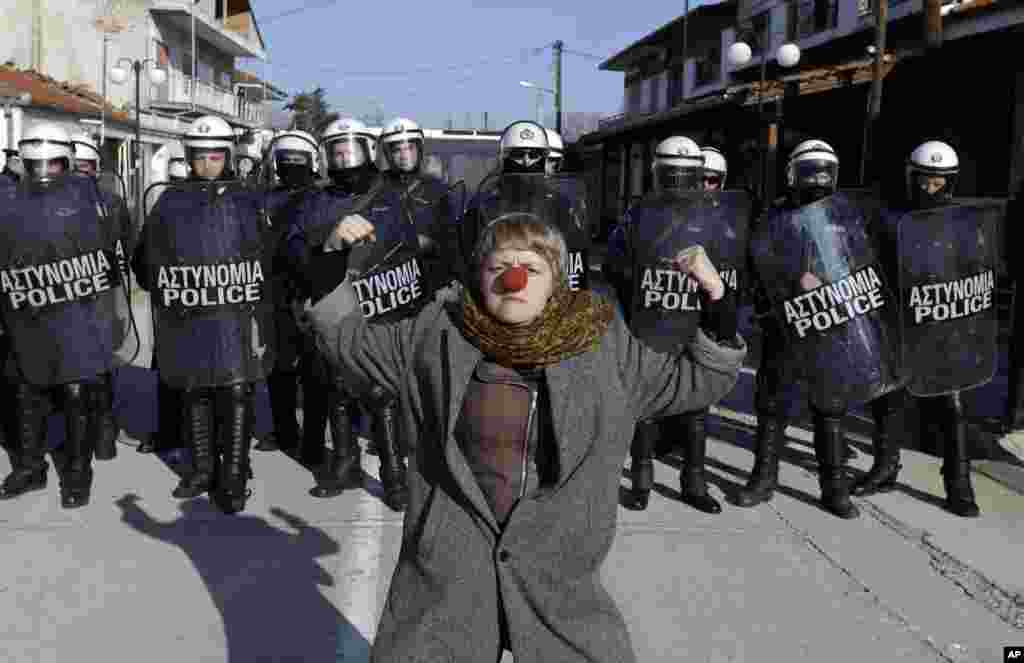A protester with a red nose poses in front of a police cordon at the Greek-Turkish border at the Greek village of Kastanies. The demonstrators held two days of rallies in the border area to demand that the government ease border transit restrictions after dozens more refugees and migrants drowned this week which crossing from Turkey to the Greek islands.