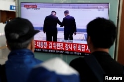 People watch a TV showing a live broadcast of the inter-Korean summit, at a railway station in Seoul, South Korea, April 27, 2018.