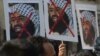 Indian activists carry placards of the leader of the Pakistan-based Jaish-e-Mohammad group, Masood Azhar, during a protest denouncing the attack on the Indian air force base in Pathankot, in Mumbai, India, Jan. 4, 2016.