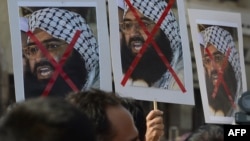 Indian activists carry placards of the leader of the Pakistan-based Jaish-e-Mohammad group, Masood Azhar, during a protest denouncing the attack on the Indian air force base in Pathankot, in Mumbai, India, Jan. 4, 2016.