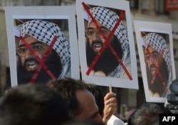 FILE - Indian activists carry placards of the leader of the Pakistan-based Jaish-e-Muhammad group, Masood Azhar, during a protest denouncing the attack on the Indian air force base in Pathankot, in Mumbai, India, Jan. 4, 2016.