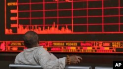 Un inversionista chino observa cómo el Índice Compuesto de Shanghai cae en una correduría en Beijing, el lunes 6 de mayo de 2019. El índice de referencia Compuesto de Shanghai de China se sumerge en la amenaza Trump de más aranceles de China.