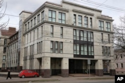 FILE - In this picture taken April 19, 2015, a women enters the four-story building known as the "troll factory" in St. Petersburg, Russia. The “troll factory” is where hundreds of young Russians work around the clock writing blogs and posting comments on the internet staunchly supporting President Vladimir Putin and attacking the West.