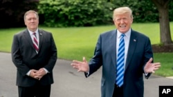 President Donald Trump, accompanied by Secretary of State Mike Pompeo, left, speaks to reporters on the South Lawn outside the Oval Office in Washington, June 1, 2018, after meeting with former North Korean military intelligence chief Kim Yong Chol. After the meeting, Trump announced that the summit with North Korea would go forward.