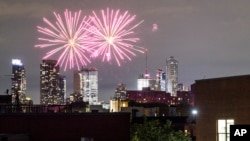 FILE - In this Friday, June 19, 2020 photo, fireworks explode during Juneteenth celebrations above the Bedford-Stuyvesant neighborhood in the Brooklyn borough of New York. The Manhattan skyline is seen in the background. (AP Photo/John Minchillo, File)