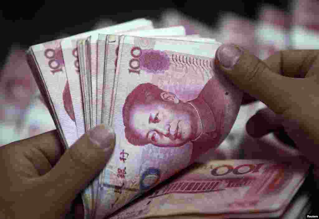6月8日，中国工商银行安徽淮北分行的一名职员在点算人民币现钞。中国继续在国际经济中发挥重要作用，例如向国际货币基金组织的危机应对基金注资430亿美元。（路透社照片）