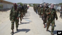 FILE - Members of Somalia's al-Shabab militant group patrol on the outskirts of Mogadishu, Somalia, March 5, 2012. 