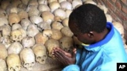A Rwandan survivor of the 1994 genocide prays over the bones of genocide victims at a mass grave in Nyamata, Rwanda, April 2004. (file photo)