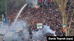 Turkish riot police use tear gas and water cannons to disperse Besiktas supporters trying to pass security barriers in front of Besiktas' new stadium, the Vodafone Arena, before the Turkish Super League soccer match between Besiktas Istanbul and Bursaspor