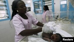 Seorang bidan sedang merawat bayi baru lahir di RSU Treichville di Abidjan, 5 Mei 2015.