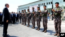 FILE - Turkey President Recep Tayyip Erdogan, left, reviews officers of the special police forces, at their headquarters in Ankara, Turkey. More than 2,500 police chiefs were among the 12,801 police suspended in connection with the failed coup attempt, Turkish authorities said in a statement.