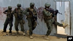 FILE - Masked Somali national army (SNA) soldiers search through homes for al-Shabab fighters, during an operation in Ealsha Biyaha, Somalia, June, 2, 2012.