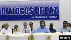 Colombia's lead government negotiator Humberto de la Calle (L) and Colombia's FARC lead negotiator Ivan Marquez (R) sit as mediators Dag Nylander of Norway (2nd L) and Rodolfo Benitez of Cuba read a joint declaration in Havana, July 12, 2015. 