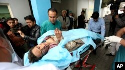 Afghans help an injured man at a hospital after a suicide attack, in Kabul, Afghanistan, Nov. 21, 2016. 
