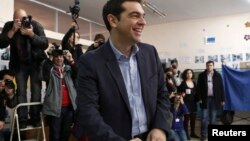 ທ່ານ Alexis Tsipras ຜູ້ນຳພັກຝ່າຍຄ້ານ ນິຍົມຊ້າຍ ຫົວຍິ້ມກ່ອນປ່ອນບັດ ທີ່ໜ່ວບປ່ອນບັດແຫ່ງນຶ່ງ
ໃນນະຄອນຫຼວງ Athens ວັນທີ 25 ມັງກອນ 2015. 