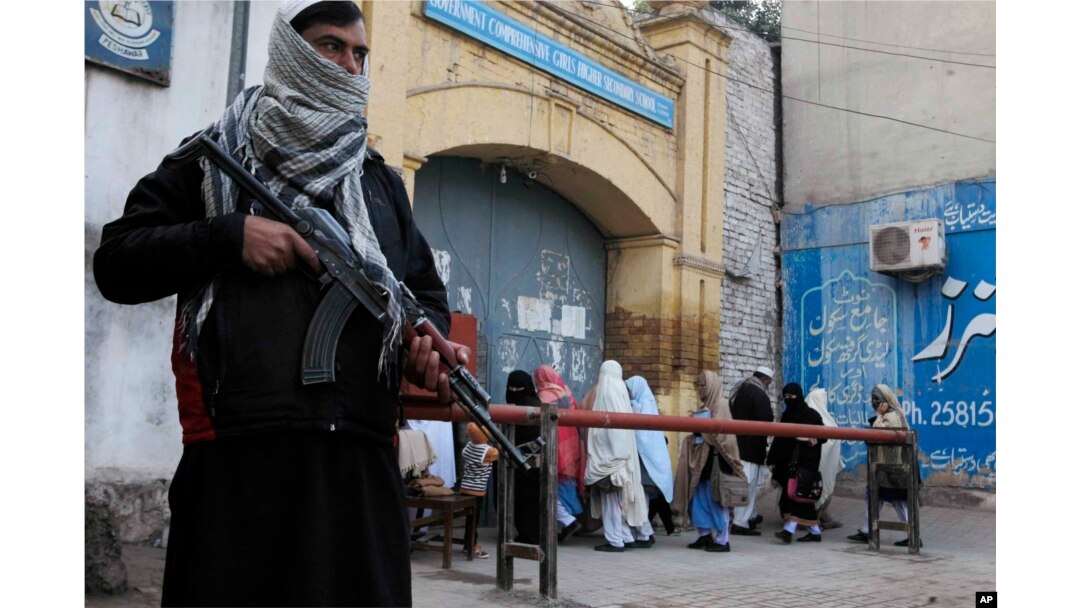 FILE - Security guards stand alert around schools and colleges following an attack on Bacha Khan University, in Peshawar, Pakistan, Jan. 21, 2016.