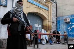 FILE - Security guards stand alert around schools and colleges following an attack on Bacha Khan University, in Peshawar, Pakistan, Jan. 21, 2016.