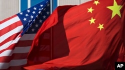 U.S. flag and China's flag flutter in winds at a hotel in Beijing, Sept. 5, 2012.