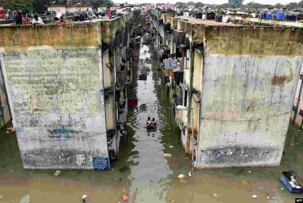 People gather around a residential area that was flooded after heavy rains in Chennai, India.