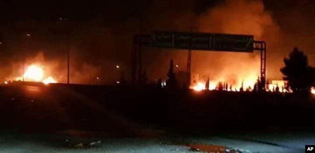 This photo released May 9, 2018 by the Syrian official news agency SANA, shows flames rising after an attack in an area known to have numerous Syrian army military bases, in Kisweh, south of Damascus, Syria.