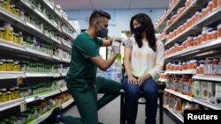 FILE - A woman receives the Pfizer-BioNTech COVID-19 vaccine as a booster dose at Skippack Pharmacy in Schwenksville, Pennsylvania, August 14, 2021.