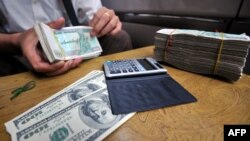 Un bureau de change illégal échangeant des billets de banque en kyats du Myanmar contre des dollars américains à Yangon, le 3 septembre 2011, au Myanmar, qui a faire appel au FMI pour de l'aide. AFP PHOTO / Soe Than WIN (Photo par Soe Than WIN / AFP)