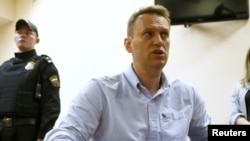 FILE - Russian opposition leader Alexei Navalny talks to journalists during a hearing at a court in Moscow, Russia, June 12, 2017. 