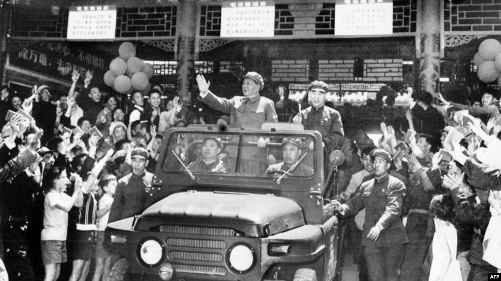历史照片：毛泽东（1893-1976）和林彪（1907-1971）在敞篷吉普车上向在北京天安门广场庆祝五一节的群众挥手致意。（1967年5月1日）