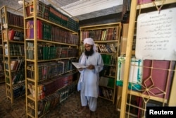 A Pakistani religious teacher refers to a book at a library at Darul Uloom Haqqania, an Islamic seminary in Akora Khattak, Khyber Pakhtunkhwa province, Sept. 14, 2013.