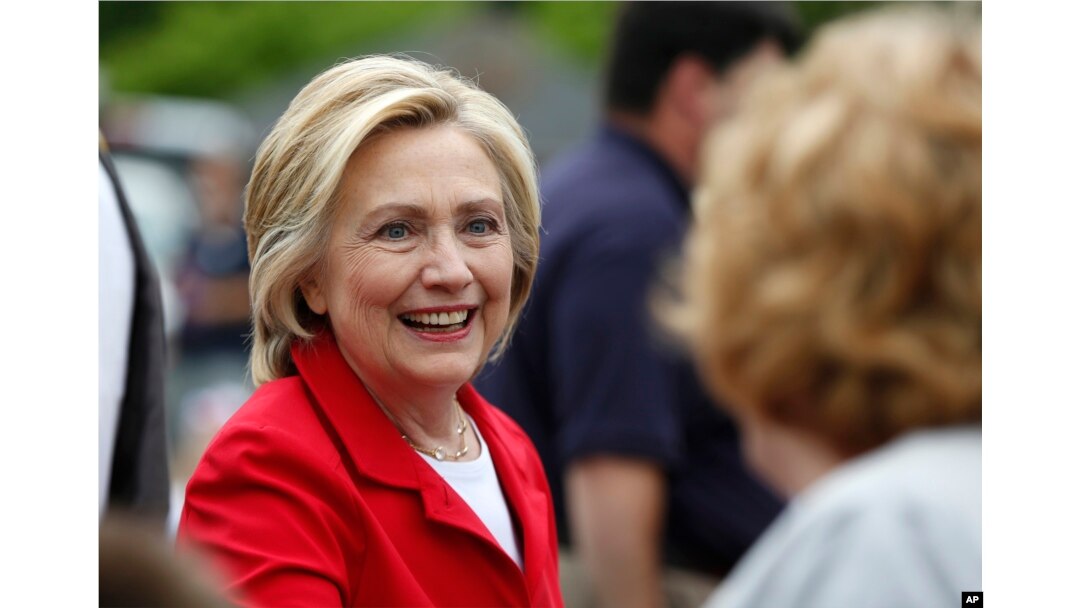 FILE - Democratic presidential candidate Hillary Rodham Clinton greets a spectator at a Fourth of July parade, July 4, 2015, in Gorham, N.H.
