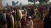 People seeking medical care wait in line outside a Doctors Without Borders health post, in a camp housing more than 40,000 people displaced by violence, at Mpoko Airport in Bangui, Central African Republic, Dec. 21, 2013.