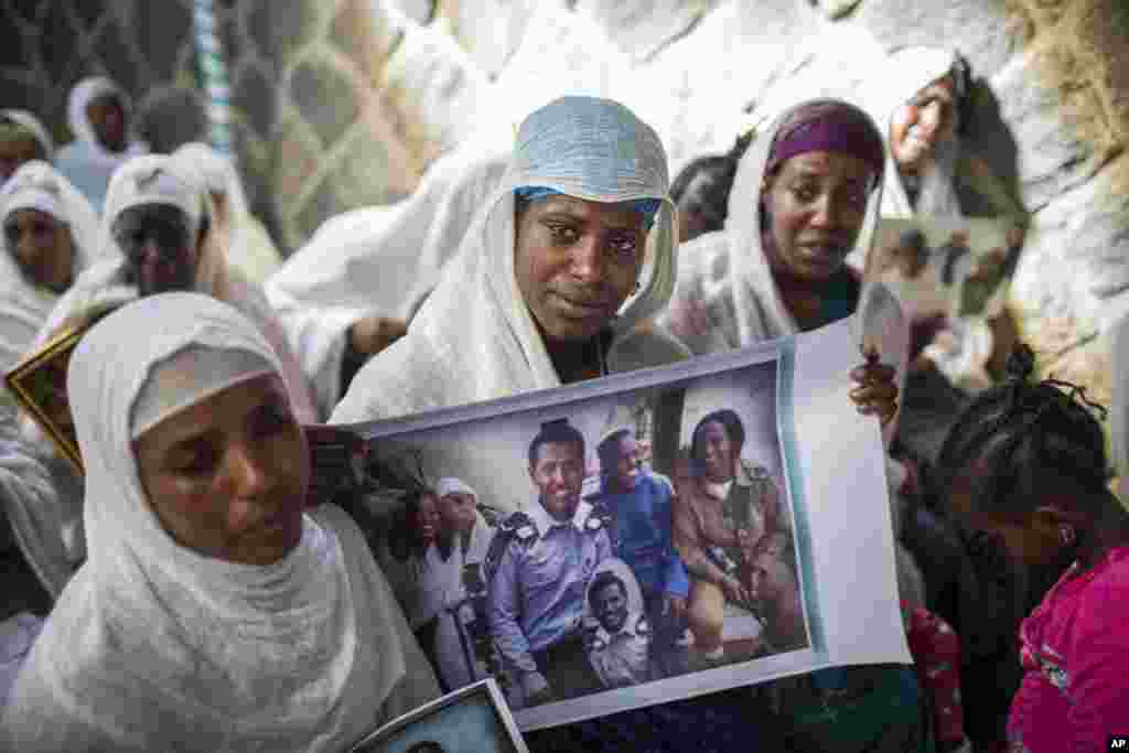 Članovi etiopske jevrejske zajednice prikazuju fotografije svojih rođaka koji žive u Izraelu tokom mitinga solidarnosti ispred jedne sinagoge u Adis Abebi. Stotine jevreja koji žive u Etiopiji okupljenih isped singagoge, strepe da će novi budžet izraelske vlade skresati sredstava za pomoć porodicama, koje žele da dovedu svoje rođake iz Etiopije.