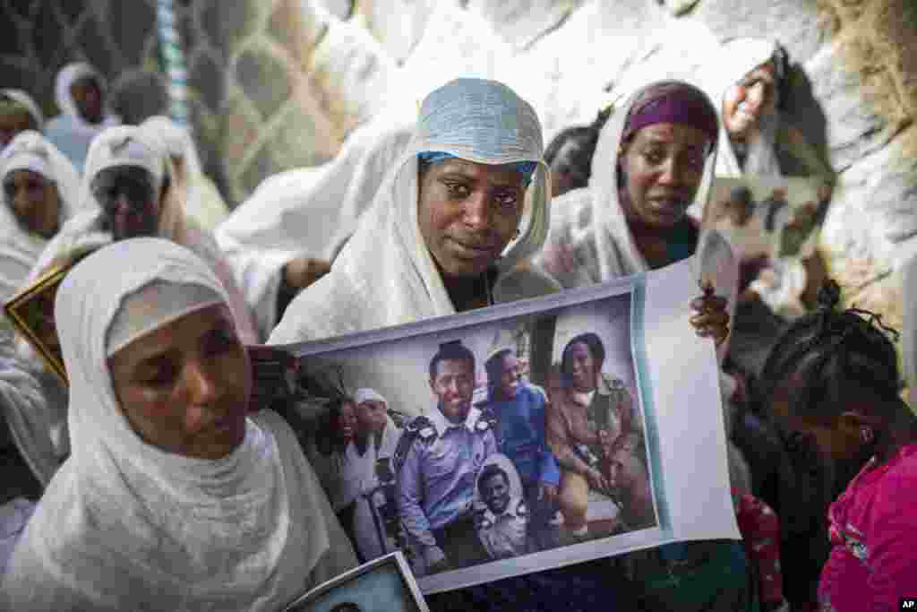 Members of Ethiopia's Jewish community hold pictures of their relatives who live in Israel, during a solidarity event at the synagogue in Addis Ababa. Hundreds of Ethiopian Jews gathered at the synagogue to express concern that Israel's proposed budget removes the funding to help them immigrate to reunite with relatives.