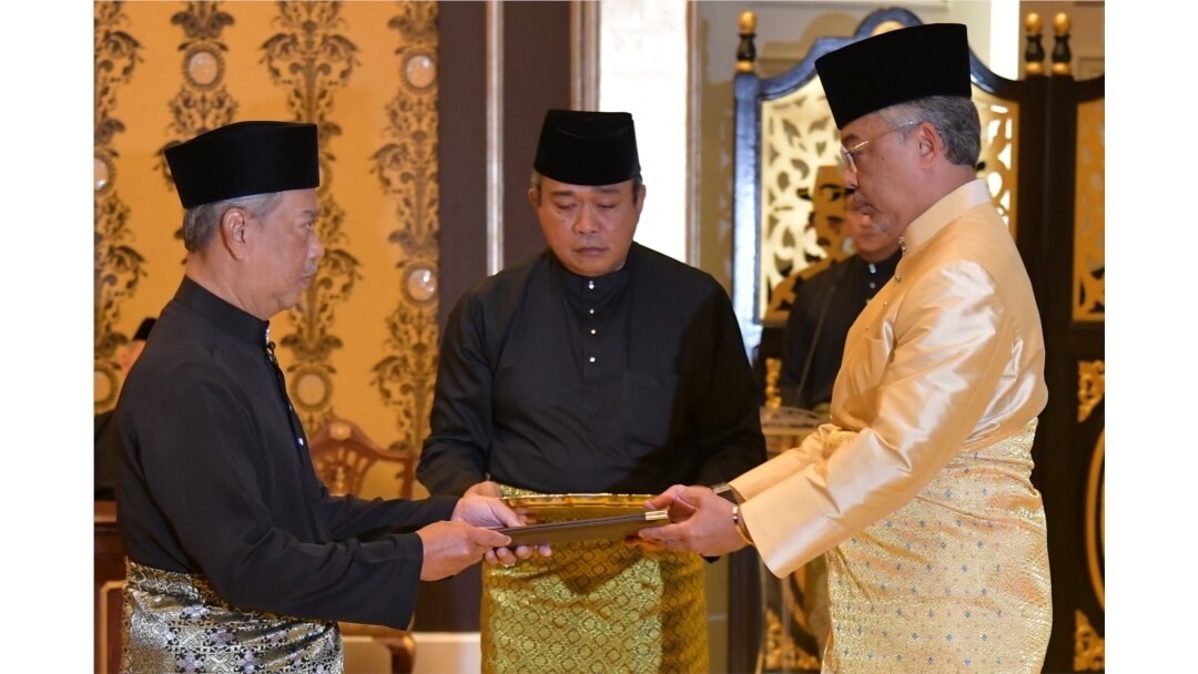 Perdana Menteri Malaysia Muhyiddin Yassin (kiri) menerima dokumen dari Raja Sultan Abdullah Sultan Ahmad Shah (kanan). (Foto: AFP)