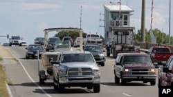 People drive over a drawbridge in Wrightsville Beach, N.C., as they evacuate the area in advance of Hurricane Florence, Tuesday, Sept. 11, 2018. (AP Photo/Chuck Burton)