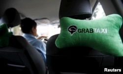 A GrabTaxi logo is seen on a car neck pillow in a taxi in Hanoi, Vietnam Sept. 9, 2015.