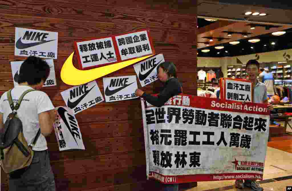 Protesters hold banners and placards during a protest outside a Nike shop at a shopping mall during Labor Day in Hong Kong, May 1, 2014 to support workers on strike at Yue Yuen Industrial Holdings Ltd. in China. 