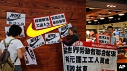 Protesters hold banners and placards during a protest outside a Nike shop at a shopping mall during Labor Day in Hong Kong, May 1, 2014 to support workers on strike at Yue Yuen Industrial Holdings Ltd. in China. 