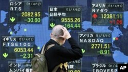 A man looks at the closing price of Japan's Nikkei share average (top C) displayed along with major indexes outside a brokerage in Tokyo, April 12, 2011