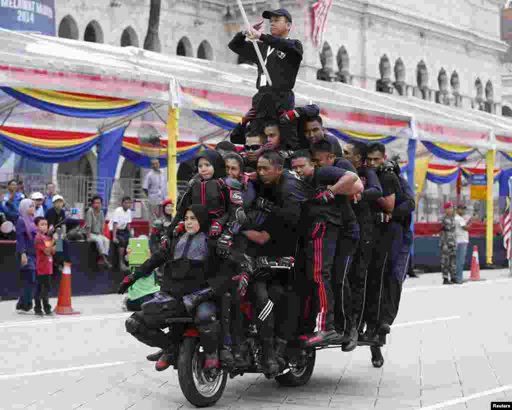 Thirty-one stunt riders balance on a motorcycle during dress rehearsals for the upcoming Independence Day celebrations in Kuala Lumpur.